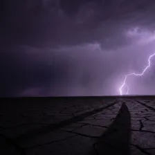 Raio atravessando um céu de tempestade ao entardecer, com uma segunda faísca subindo do chão ao encontro da primeira